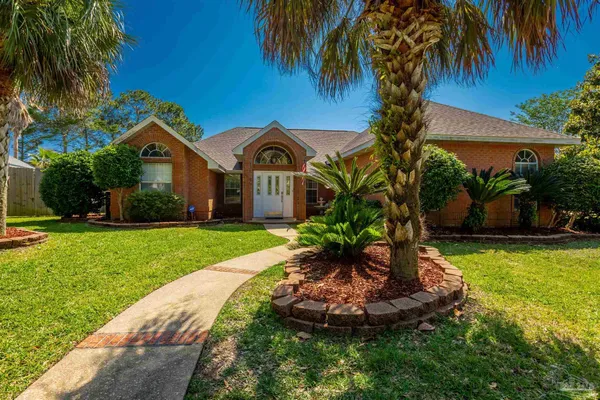 a front view of a house with a yard and palm tree