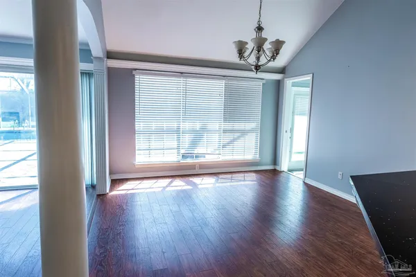 a view of a hallway with wooden floor and a kitchen
