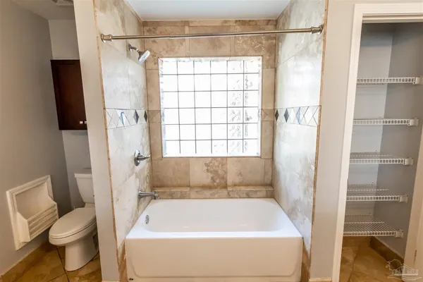 a bathroom with a tub sink and mirror