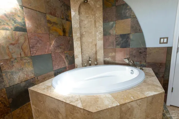 a bathroom with a tub sink and mirror