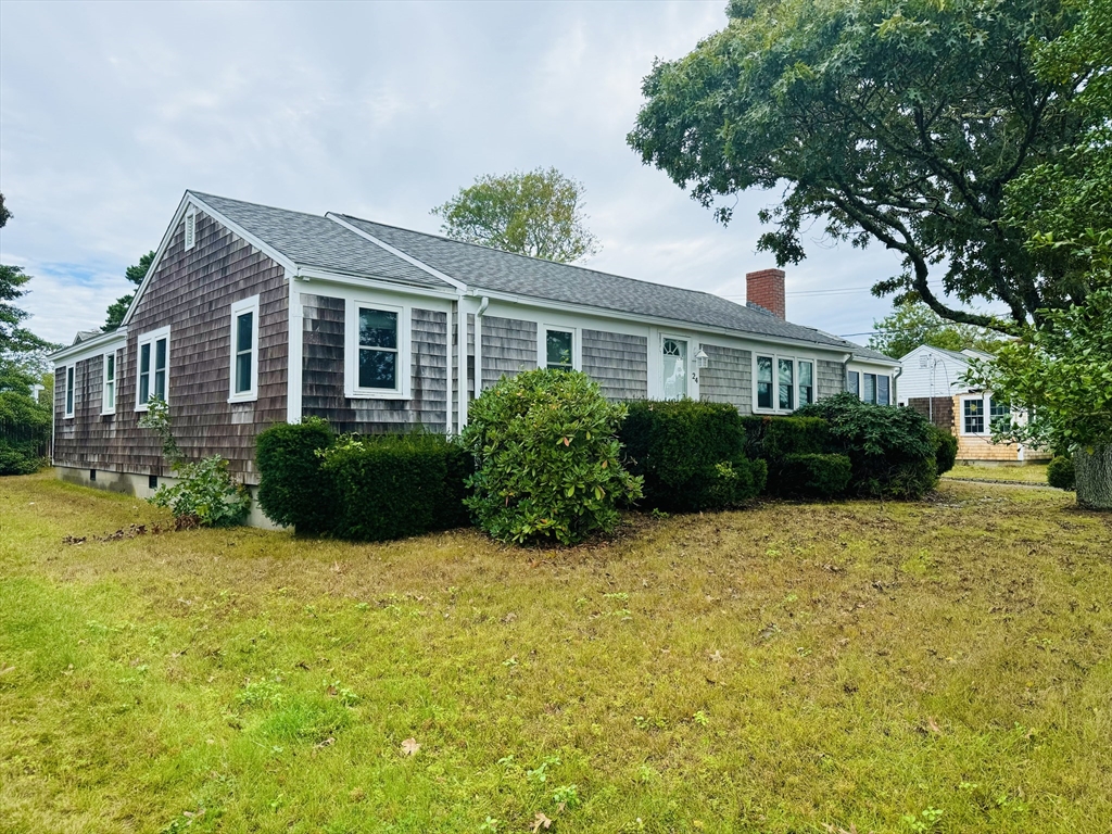 a front view of a house with yard and green space