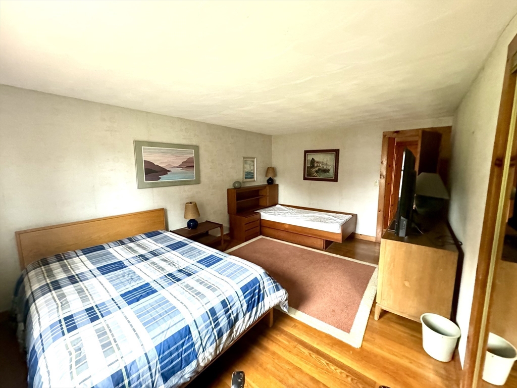 24 Shore Road West Dennis, MA 02670 - Photo 15 of 28 a bedroom with a bed and wooden floor