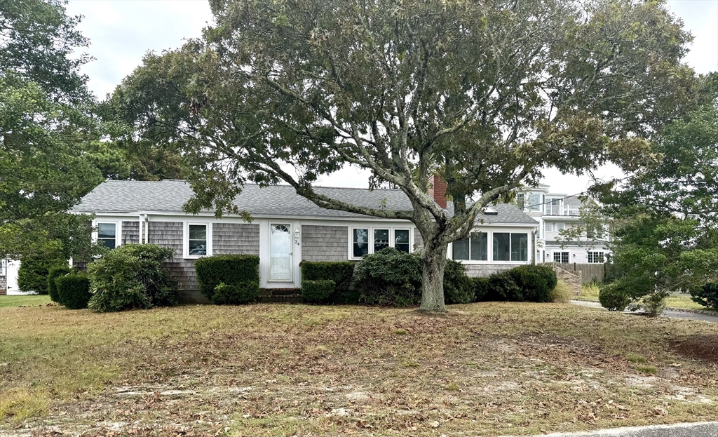24 Shore Road West Dennis, MA 02670 - Photo 2 of 28 a front view of a house with a garden