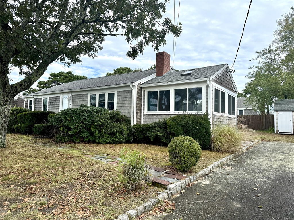 24 Shore Road West Dennis, MA 02670 - Photo 3 of 28 a front view of a house with yard