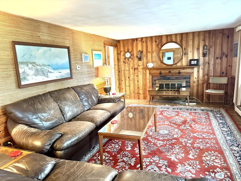 24 Shore Road West Dennis, MA 02670 - Photo 5 of 28 a living room with furniture a rug and a fireplace
