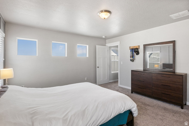 5155 East Rio Grande Way Eagle Mountain, UT 84005 - Photo 19 of 40 Bedroom featuring light carpet and a textured ceiling