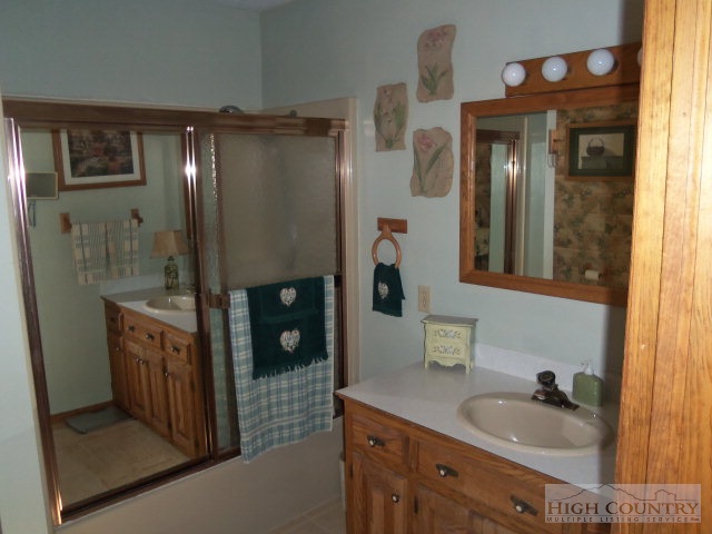 727 Teaberry Road Warrensville, NC 28693 - Photo 12 of 15 a bathroom with a sink a mirror and a shower