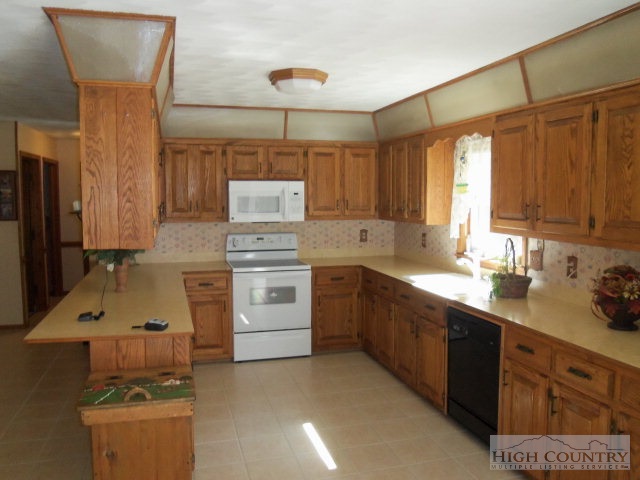 727 Teaberry Road Warrensville, NC 28693 - Photo 14 of 15 a kitchen with a sink stove and cabinets