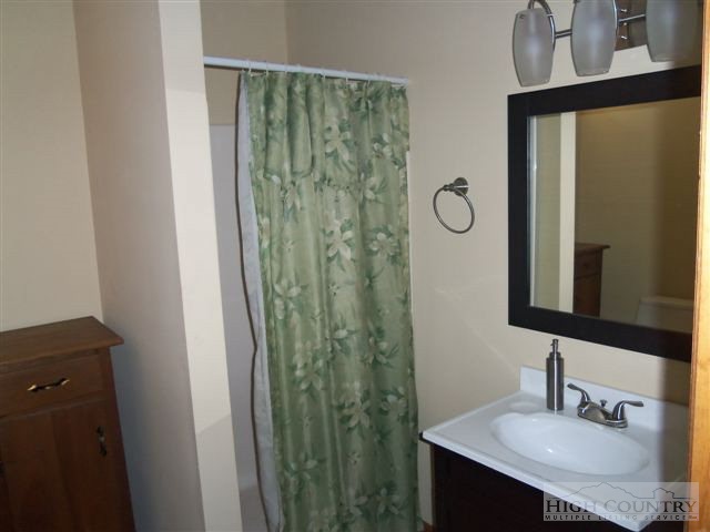 727 Teaberry Road Warrensville, NC 28693 - Photo 4 of 15 a bathroom with a sink vanity and a mirror