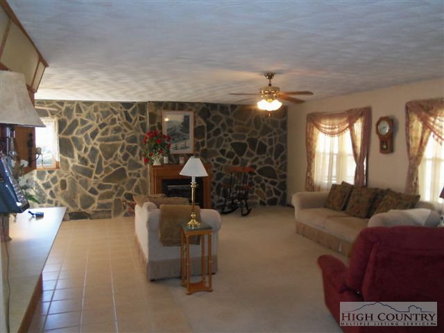 727 Teaberry Road Warrensville, NC 28693 - Photo 7 of 15 a living room with furniture a lamp and a fireplace