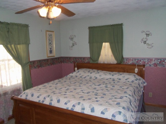 727 Teaberry Road Warrensville, NC 28693 - Photo 9 of 15 a bed sitting in a bedroom next to a window