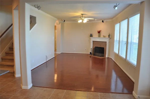 a view of an empty room with window wooden floor and a kitchen