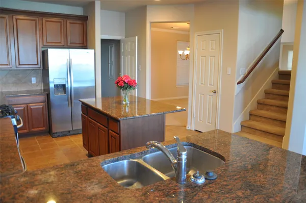 a kitchen with stainless steel appliances granite countertop a sink a stove counter space and cabinets