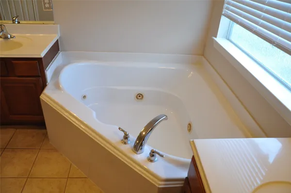 a bathroom with a tub sink and mirror