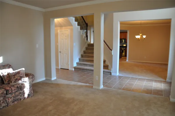 a view of a livingroom with wooden floor and stairs