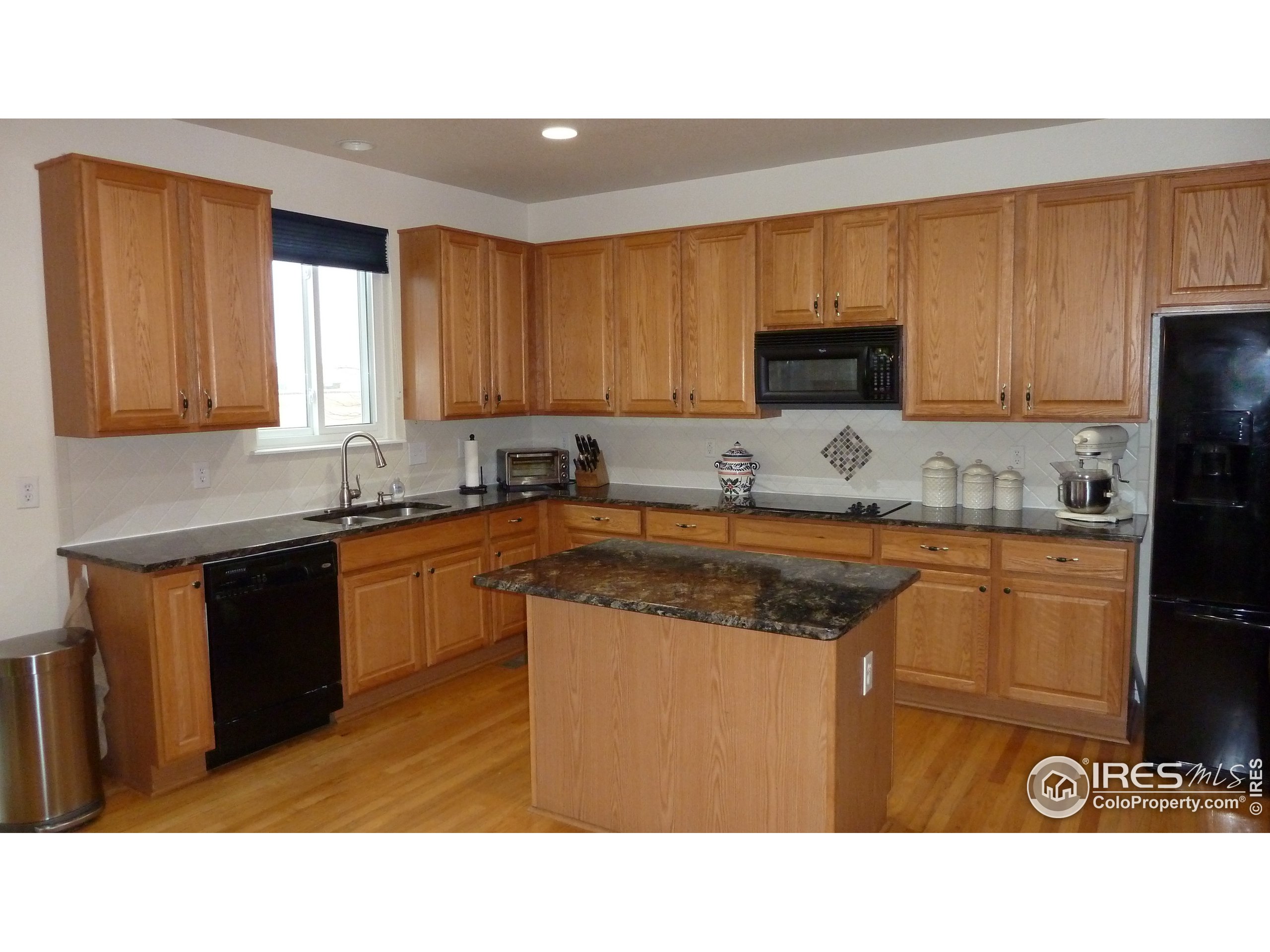 8121 Raspberry Drive Frederick, CO 80504 - Photo 2 of 38 a kitchen with stainless steel appliances granite countertop a stove a sink dishwasher and a microwave oven with cabinets