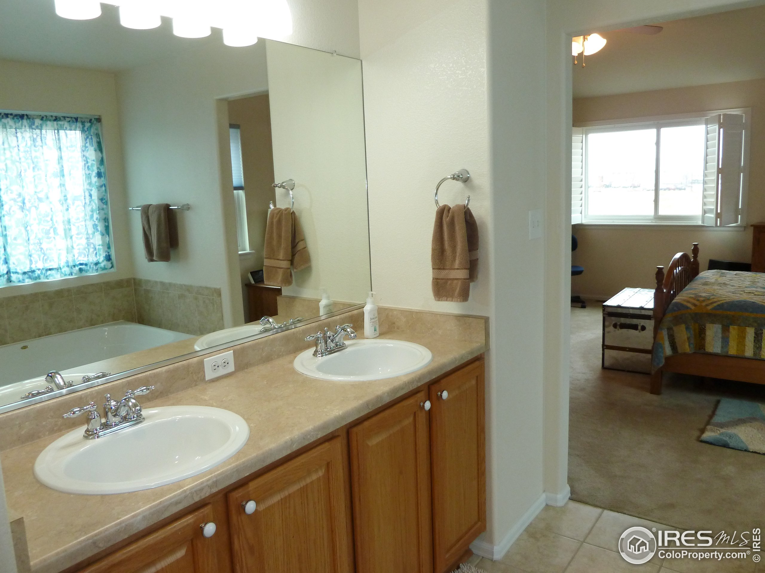 8121 Raspberry Drive Frederick, CO 80504 - Photo 21 of 38 a bathroom with a double vanity sink and a mirror