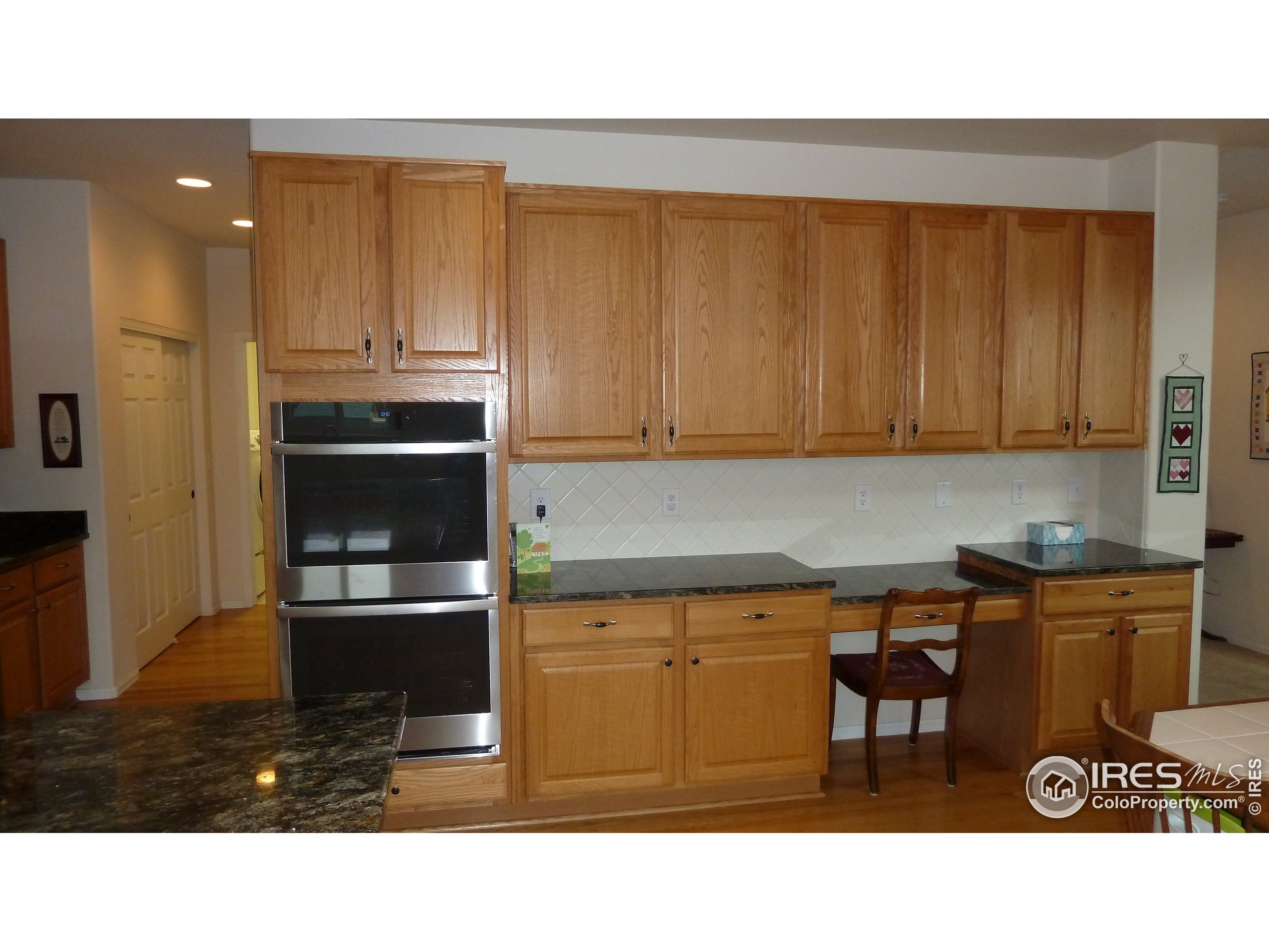 8121 Raspberry Drive Frederick, CO 80504 - Photo 6 of 38 a kitchen with stainless steel appliances kitchen island granite countertop a refrigerator and cabinets