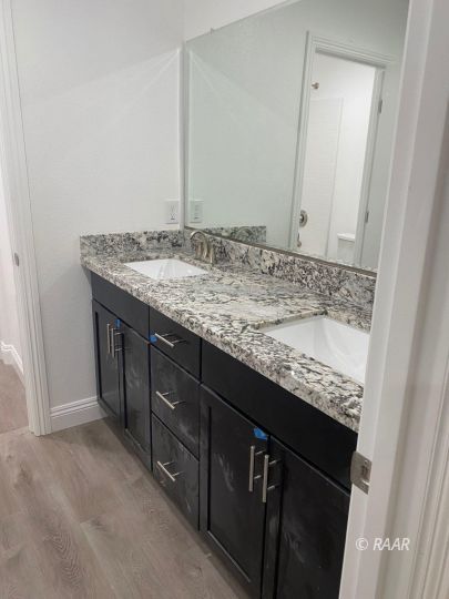 1124 South Yorktown Street Ridgecrest, CA 93555 - Photo 7 of 13 a bathroom with a granite countertop sink and a mirror