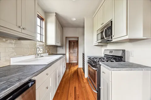 a kitchen with stainless steel appliances granite countertop a stove and a sink