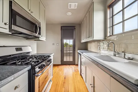 a kitchen with stainless steel appliances granite countertop a stove and a sink