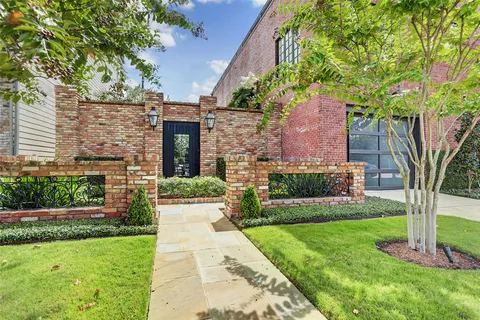 a front view of a house with a yard and potted plants