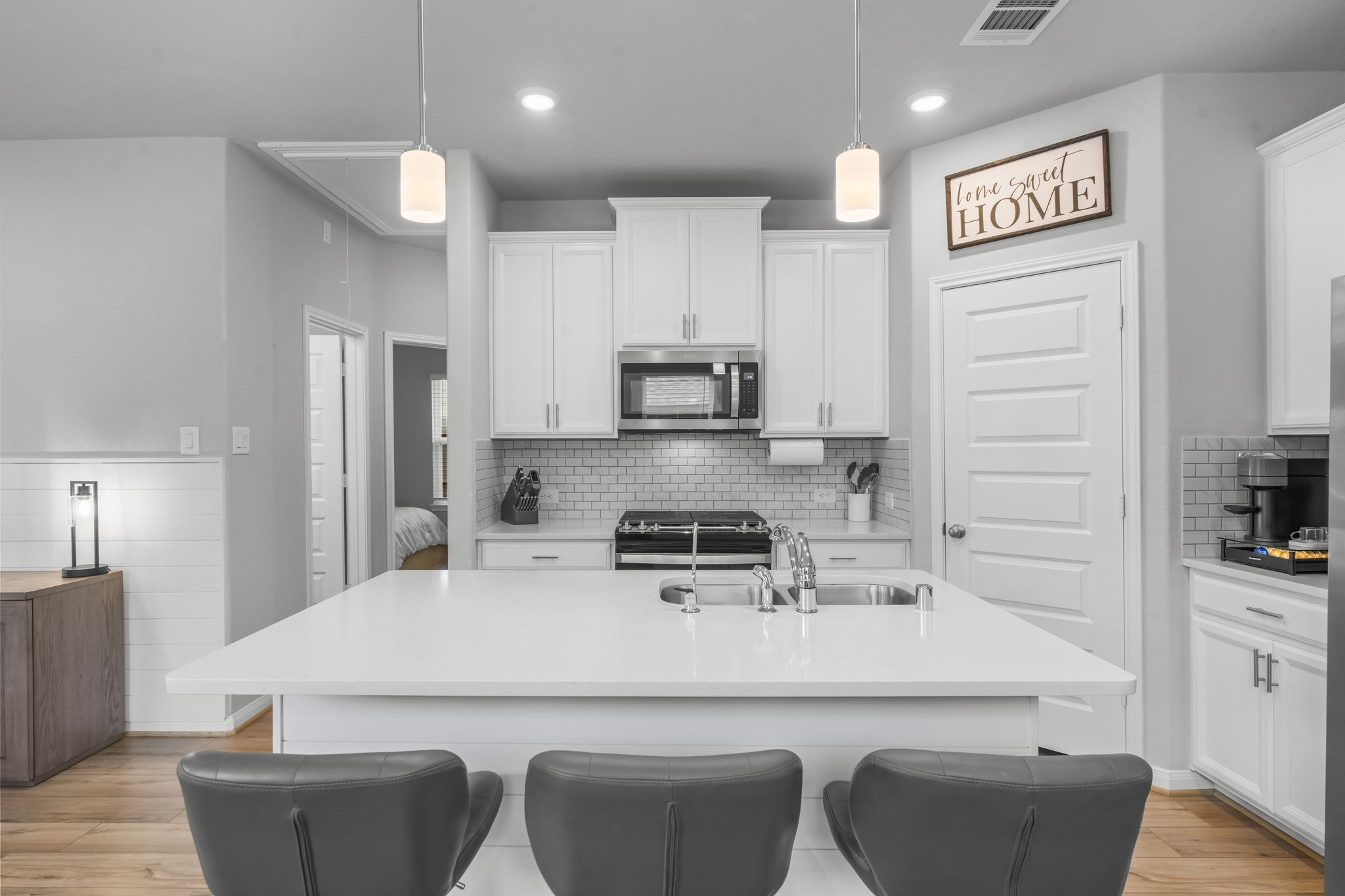 18581 Meadow Point Lane Montgomery, TX 77316 - Photo 7 of 44 a kitchen with stainless steel appliances a refrigerator a stove a sink and white cabinets with wooden floor