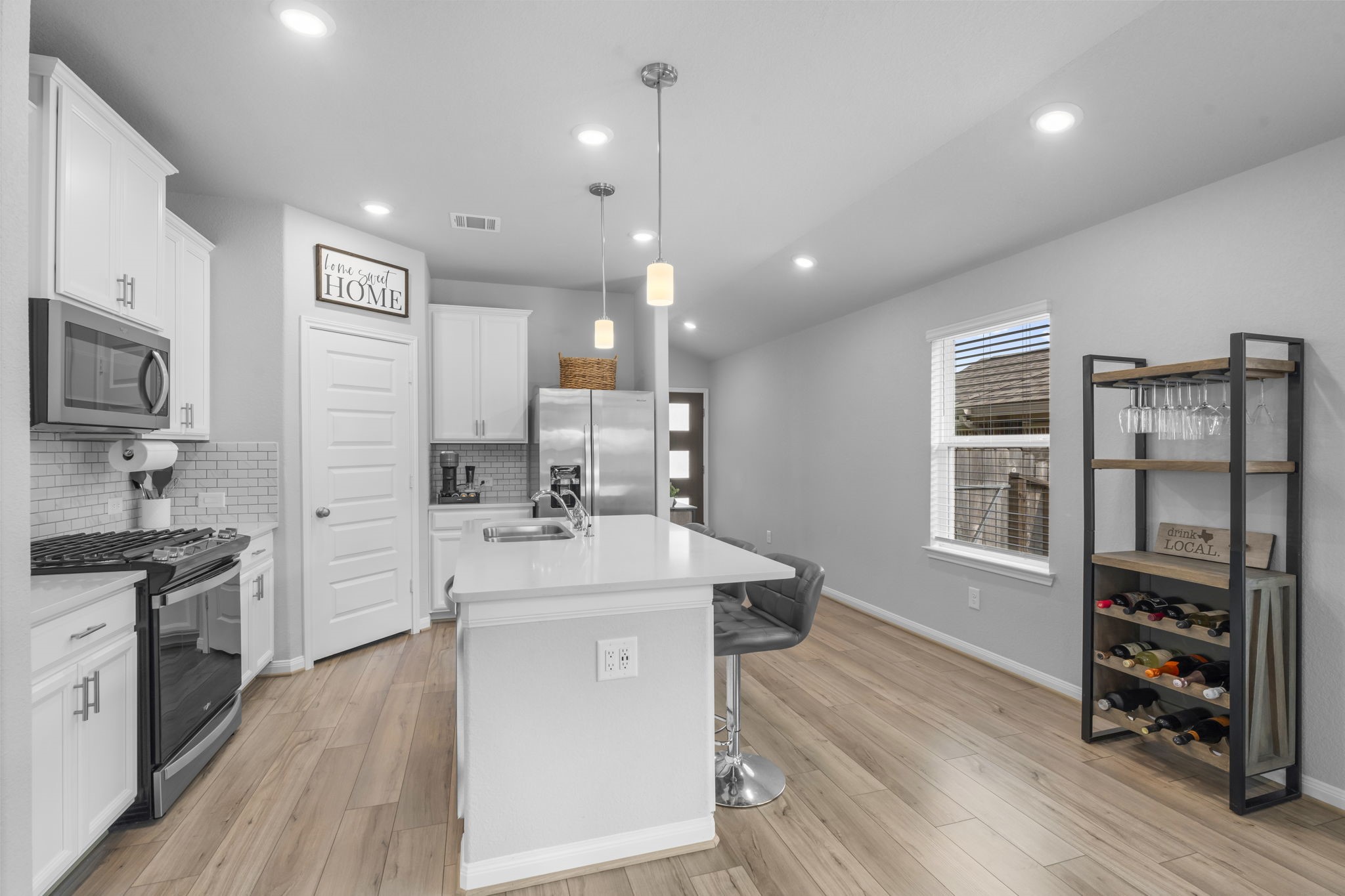 18581 Meadow Point Lane Montgomery, TX 77316 - Photo 9 of 44 a large kitchen with stainless steel appliances a large counter top a stove a chimney a sink and a refrigerator