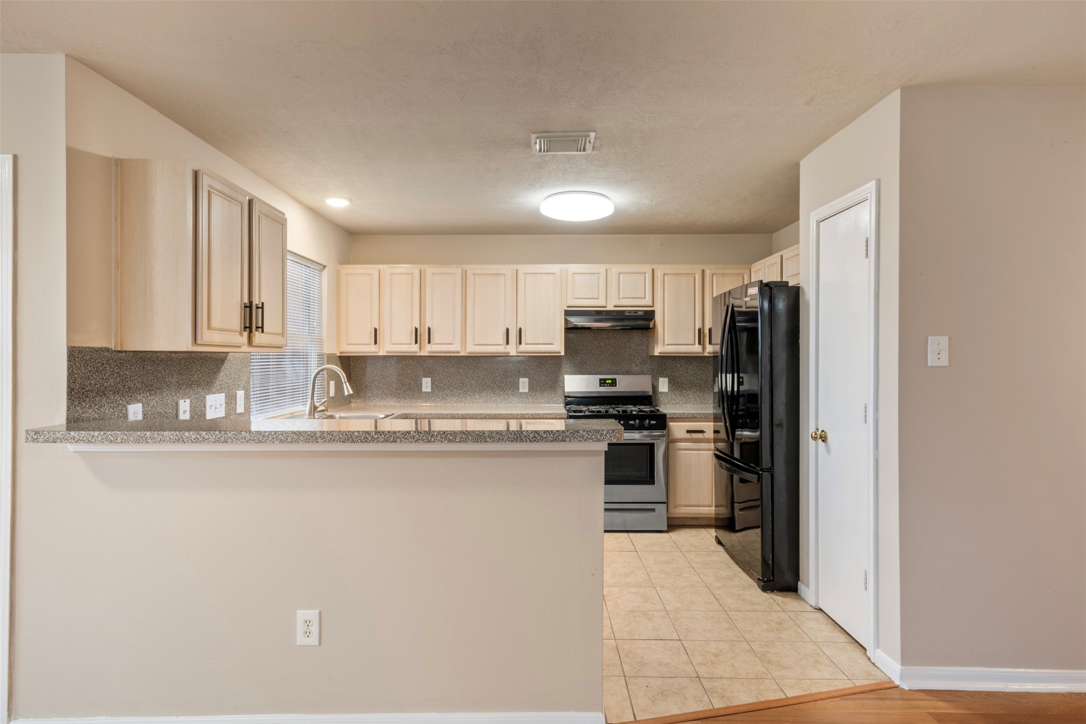 13615 Ambrose Street Houston, TX 77045 - Photo 11 of 35 a kitchen with stainless steel appliances granite countertop a refrigerator stove top oven and sink