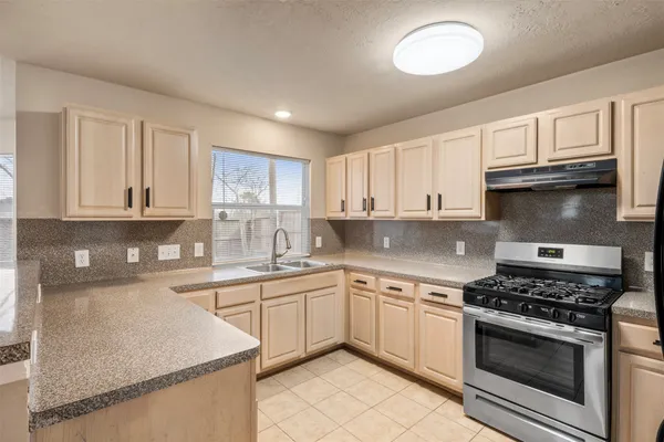 a kitchen with cabinets appliances a sink and a window