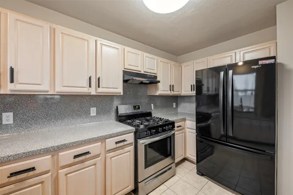 a kitchen with cabinets stainless steel appliances and a counter space