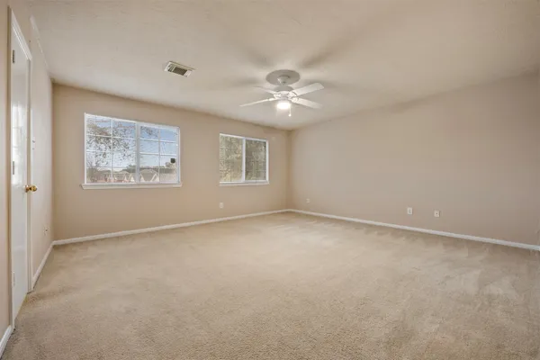 an empty room with a window and a ceiling fan