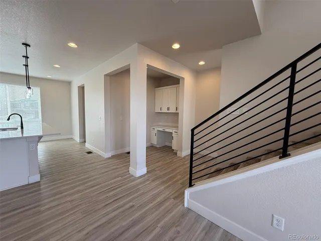 a view of a hallway with wooden floor and staircase