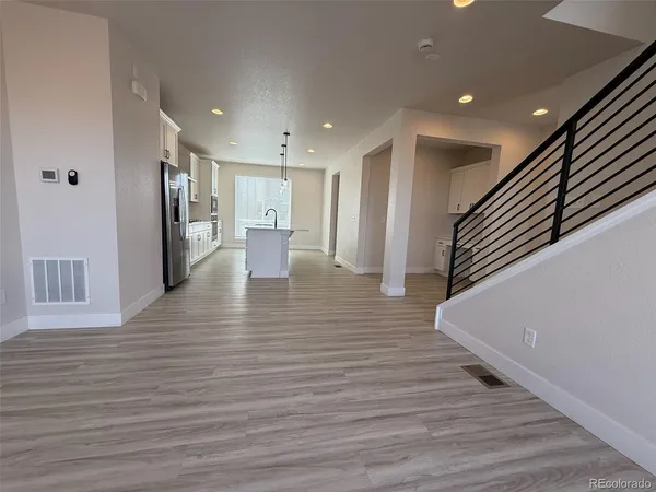 a view of a hallway with wooden floor and staircase