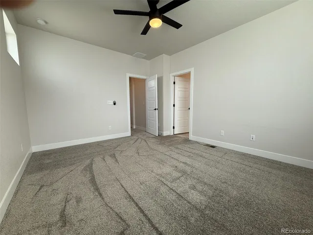 an empty room with closet and windows