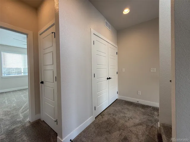 an empty room with closet and windows