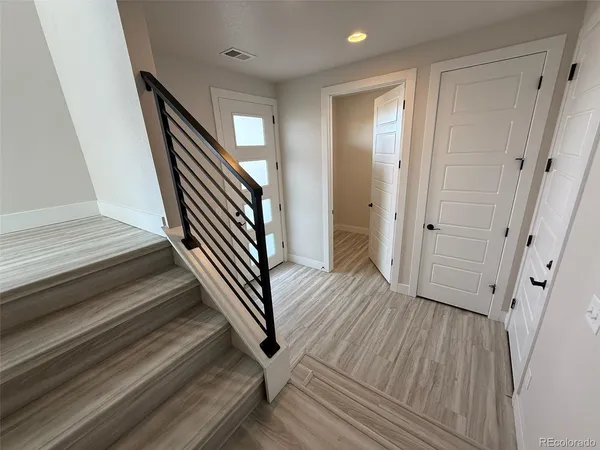 a view of a hallway with wooden floor and staircase