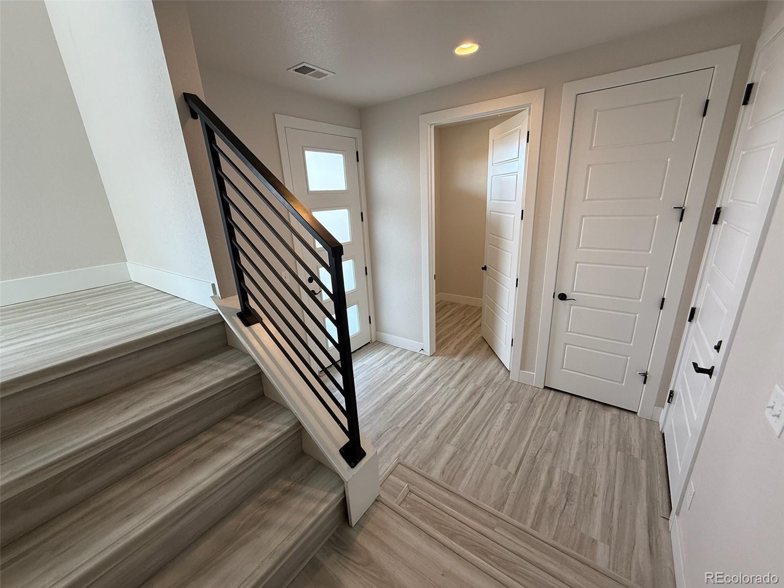 12355 Farmview Lane Thornton, CO 80241 - Photo 5 of 42 a view of a hallway with wooden floor and staircase