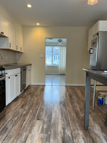 a kitchen with a wooden floor and a stove top oven