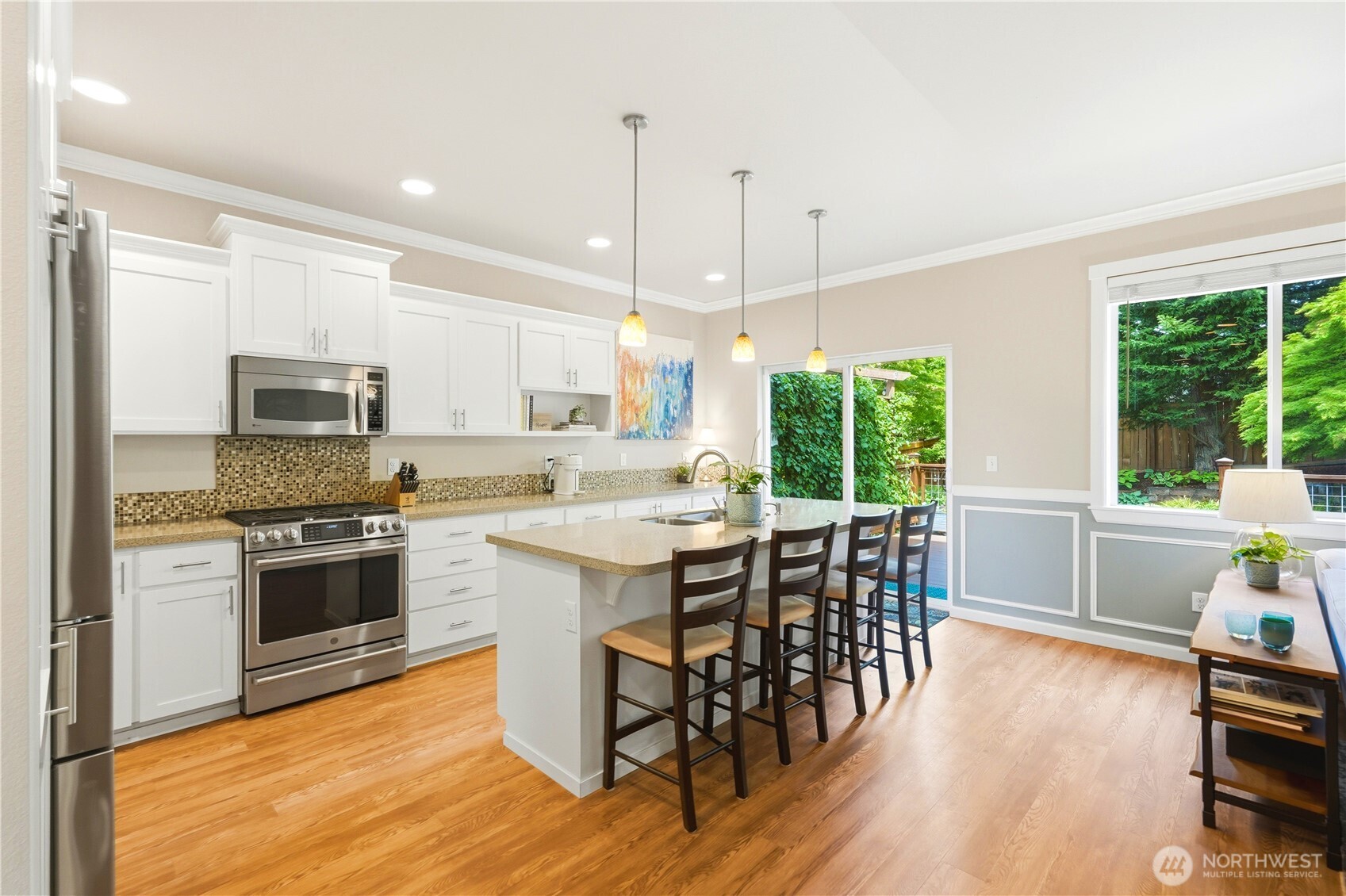 13410 Southeast 252nd Street Kent, WA 98042 - Photo 14 of 38 a kitchen with stainless steel appliances granite countertop a stove top oven a sink a dining table and chairs with wooden floor