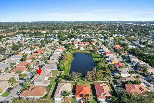 an aerial view of residential houses with outdoor space and ocean view