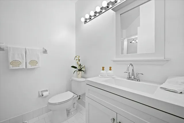 a bathroom with a sink a toilet and mirror