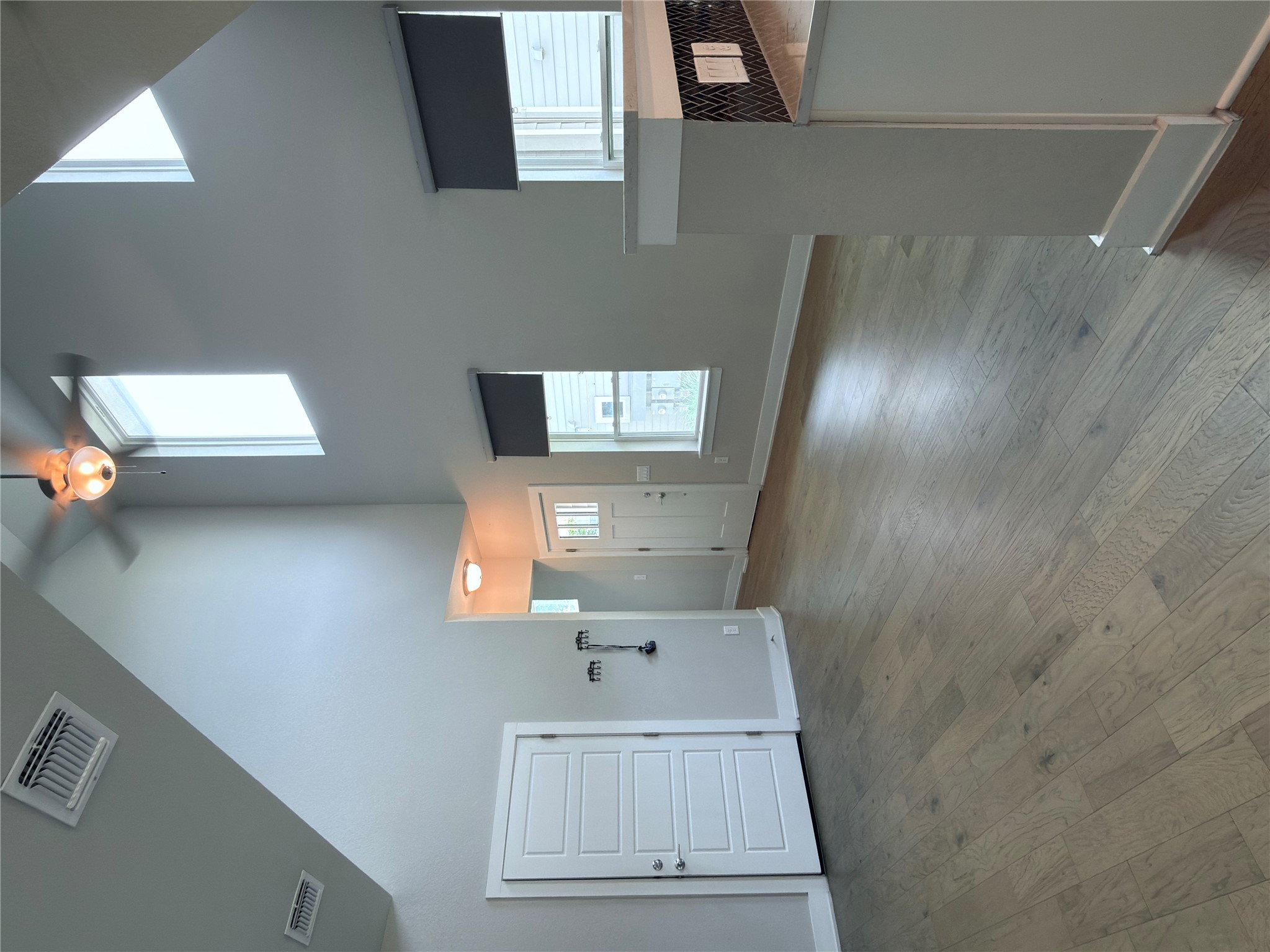 11216 Gadsen Lane Austin, TX 78754 - Photo 7 of 36 Natural light floods this living space, featuring high vaulted ceilings and durable wood flooring.