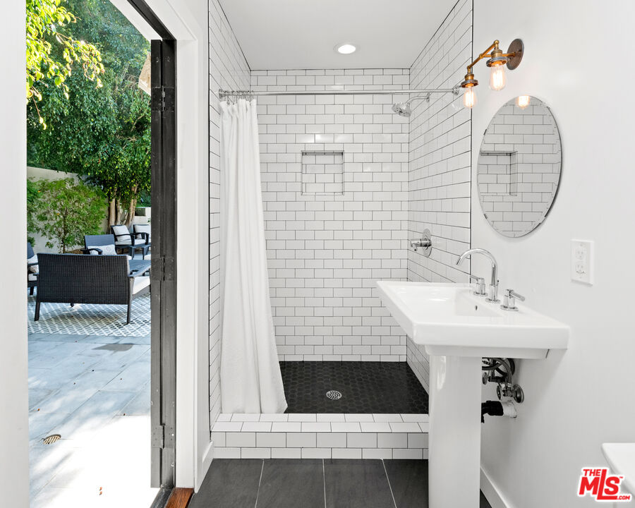 1944 North Beverly Drive Beverly Hills, CA 90210 - Photo 15 of 29 a bathroom with a sink a mirror and shower