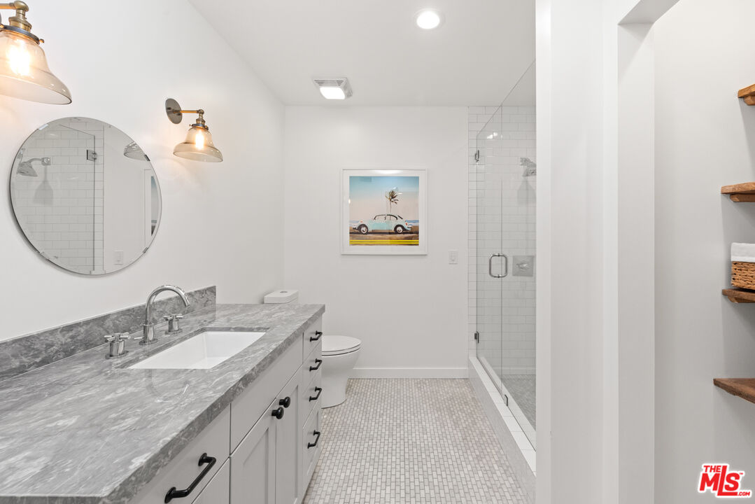 1944 North Beverly Drive Beverly Hills, CA 90210 - Photo 18 of 29 a bathroom with a granite countertop sink mirror and vanity