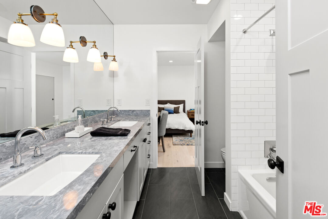 1944 North Beverly Drive Beverly Hills, CA 90210 - Photo 20 of 29 a bathroom with a sink vanity granite tub and shower