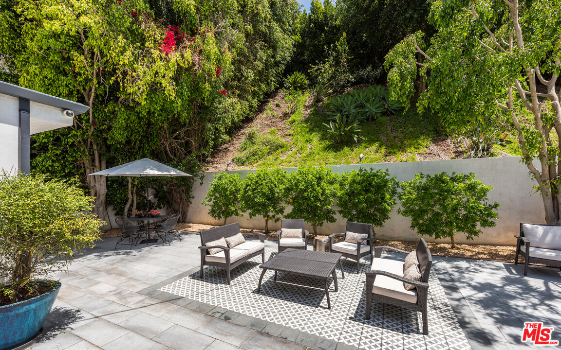 1944 North Beverly Drive Beverly Hills, CA 90210 - Photo 25 of 29 a patio with table and chairs and potted plants