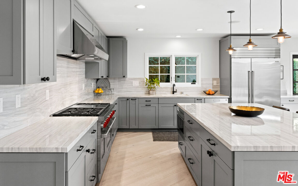 1944 North Beverly Drive Beverly Hills, CA 90210 - Photo 3 of 29 a kitchen with a sink stove and cabinets