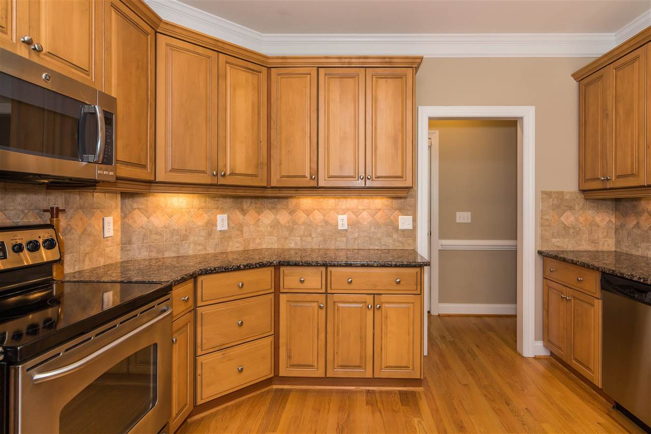 1132 Rhea Drive Garner, NC 27529 - Photo 8 of 25 Beautiful granite countertops, abundant cabinetry, tile backsplash, stainless appliances, and a breakfast bar all combine to make this the perfect family kitchen - easy for cooking and spending time together! Kitchen