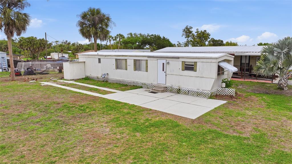 11923 Southwest Loop Terrace Arcadia, FL 34269 - Photo 47 of 50 a front view of a house with a yard and trees